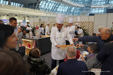 Wicemarszałek Piotr Pilch  częstuje uczestników targów ciasteczkami wypieczonymi podczas gotowania Vip-ów
