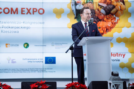 Marszałek w garniturze przemawia z mównicy podczas wydarzenia EKOGALA. W tle widoczny duży ekran z grafiką promującą Międzynarodowe Targi Produktów i Żywności Wysokiej Jakości wraz z logotypami.”