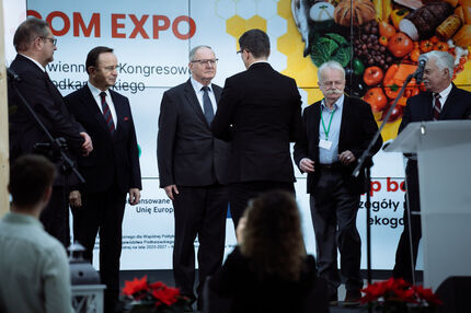 Na scenie Prezes Wojewódzkiego Związku Pszczelarzy wręcza odznaczenia pszczelarzom